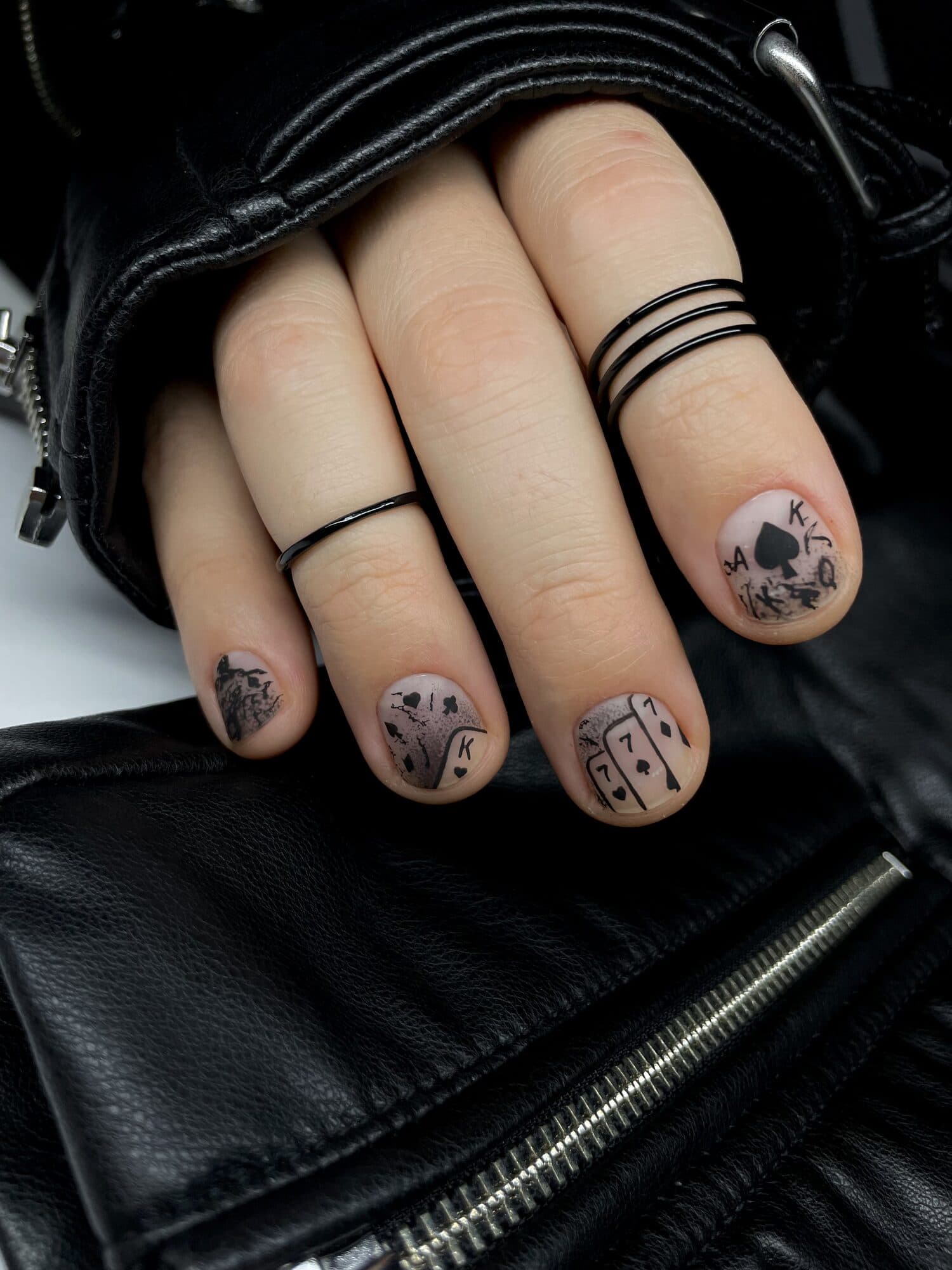 Short nails with printed black and white art, styled with a leather bag