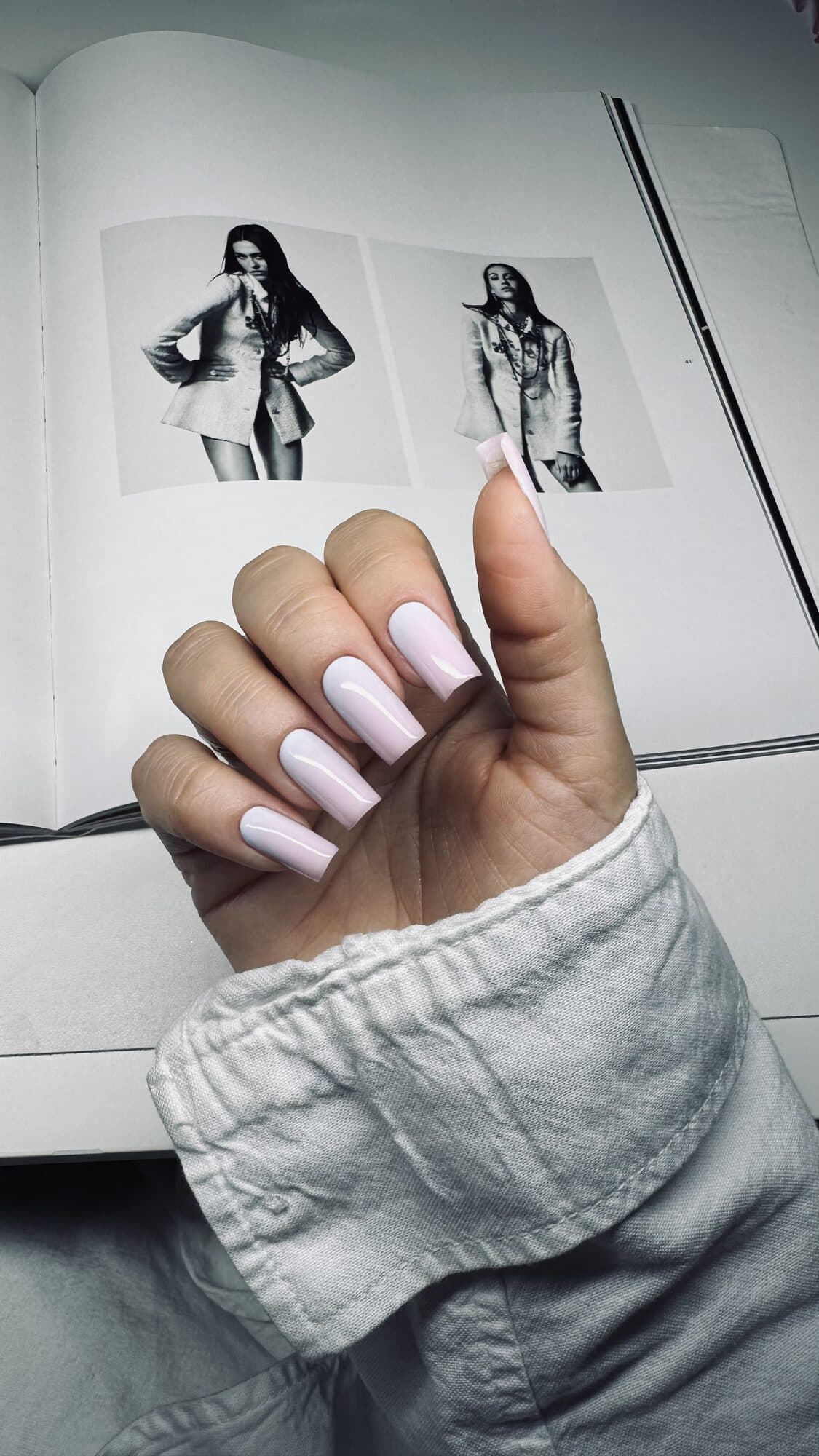 Soft lilac square nails over a black and white magazine