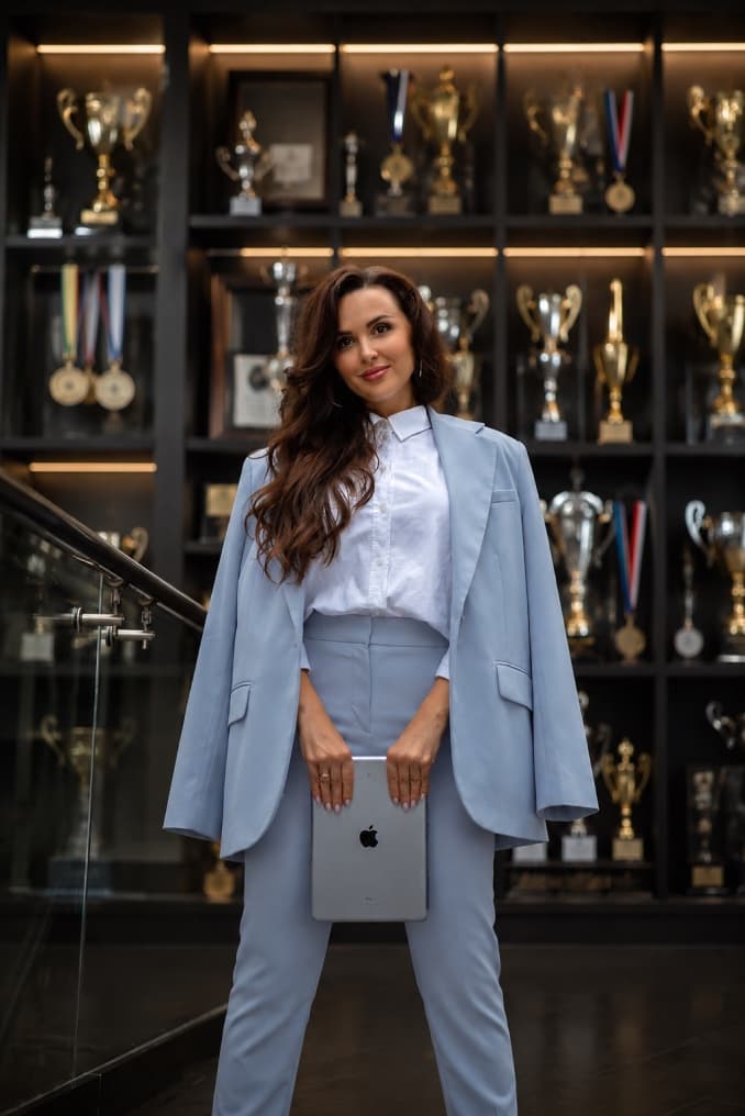Yuliia Cherbadzhy standing in front of her competition trophies